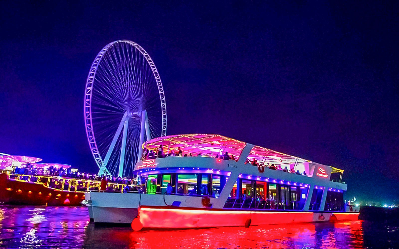 Dubai Marina dinner cruise with live music, featuring illuminated skyline and luxury yachts.