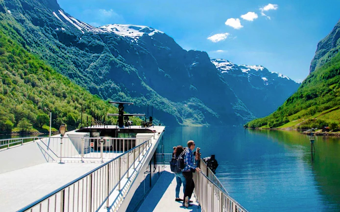 Cruise ship on Nærøyfjord with passengers enjoying views of mountains, Western Norway.