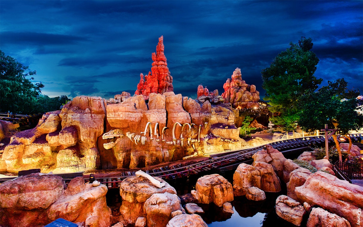Frontierland's Big Thunder Mountain Railroad at Disneyland Park, California, with rocky landscape.