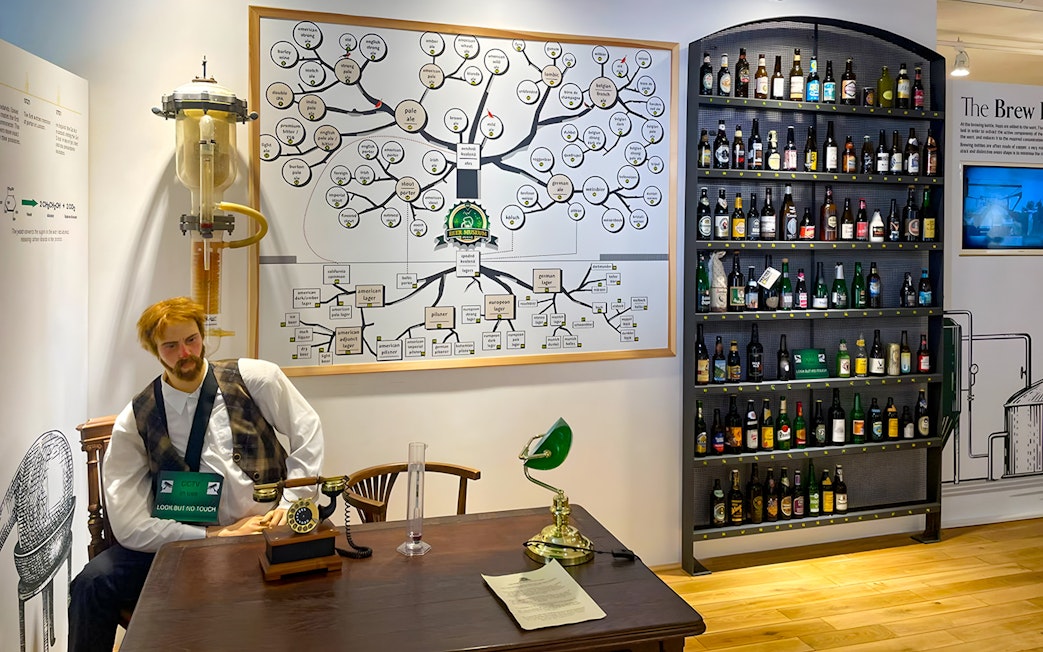 Prague Beer Museum interior with beer bottle display and brewing process chart.