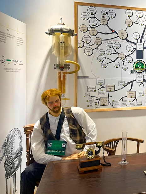Prague Beer Museum interior with beer bottle display and brewing process chart.