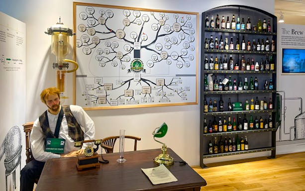 Prague Beer Museum interior with beer bottle display and brewing process chart.