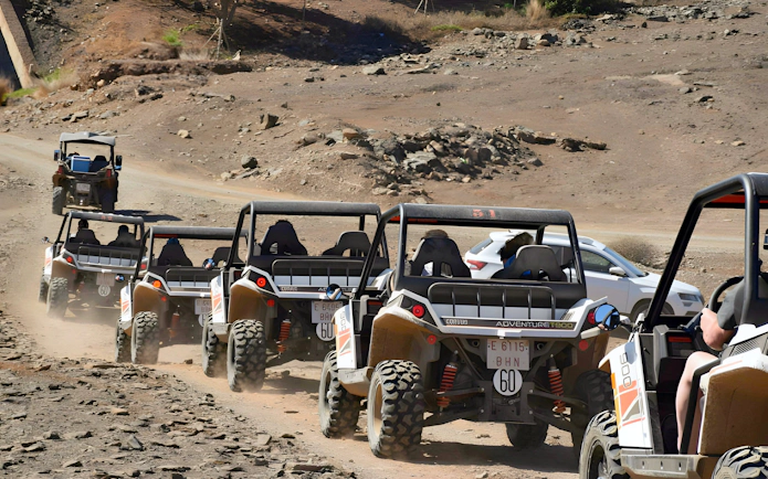 Off-road buggies driving on a dusty trail in Gran Canaria.