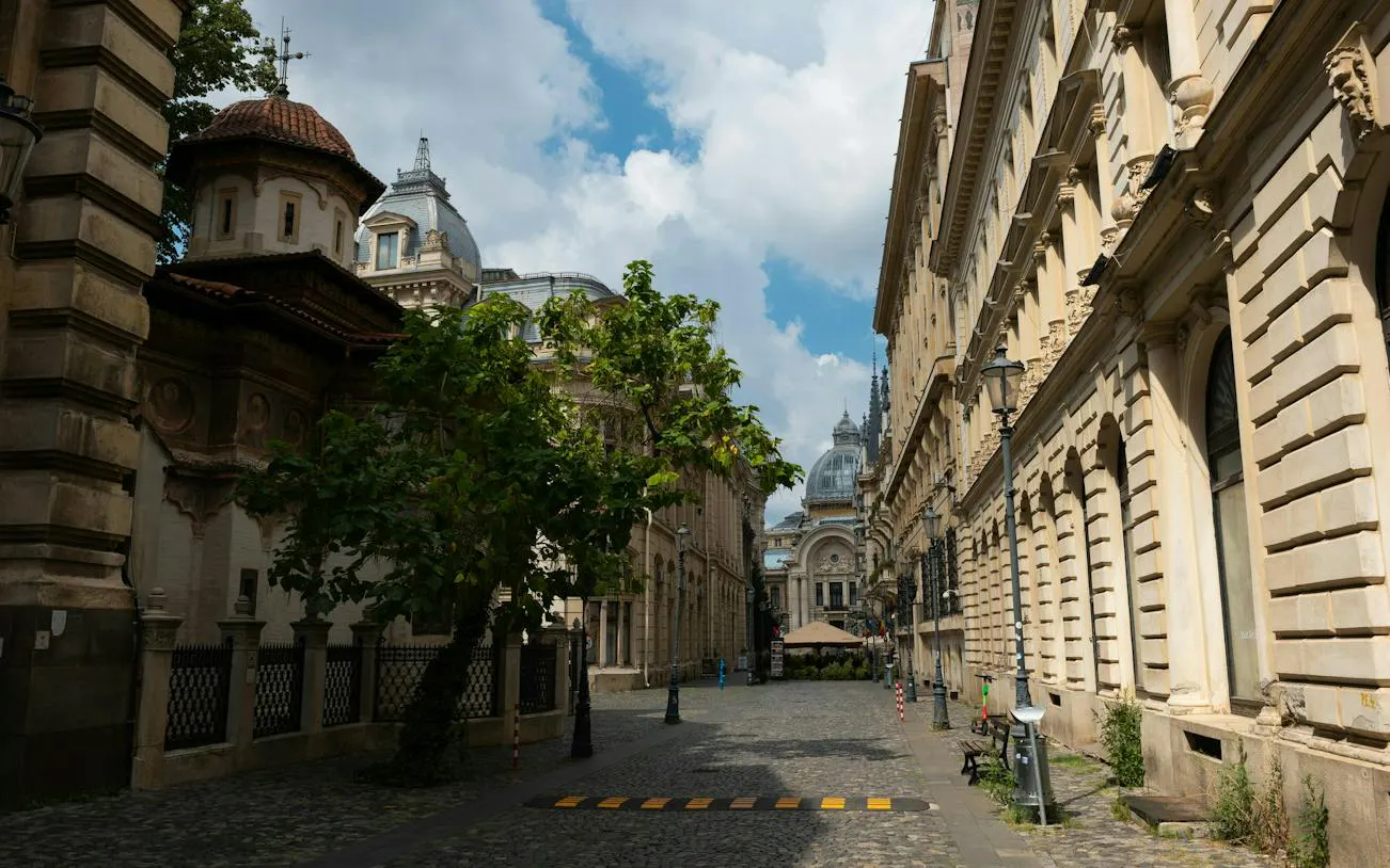 Cobblestone street in Bucharest with historic architecture, part of the self-guided city exploration game.
