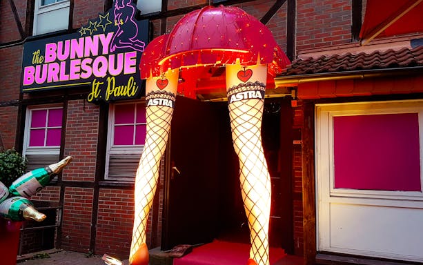 Entrance to Bunny Burlesque St. Pauli in Hamburg with illuminated leg decor.
