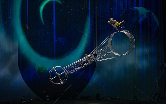 Performer balancing on Wheel of Life during La Perle show in Dubai.