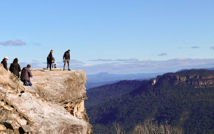 Visitors standing on Lincoln's Rock with Blue Mountains view, NSW, Australia.