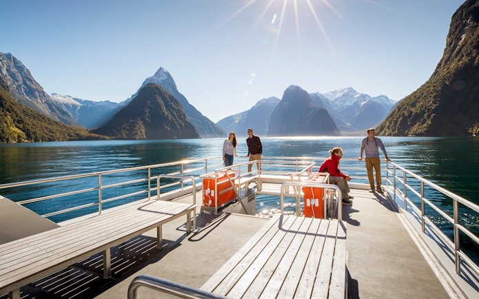 Cruise passengers enjoying Milford Sound views with mountains and clear water.