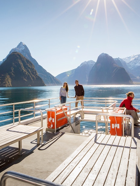 Cruise passengers enjoying Milford Sound views with mountains and clear water.