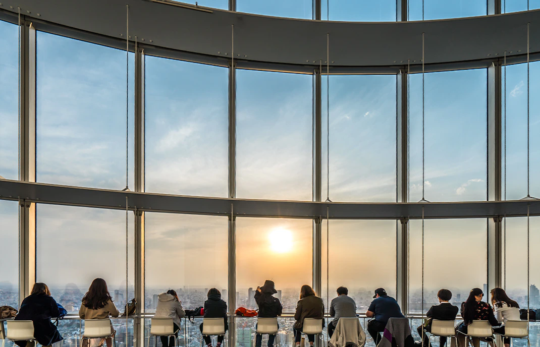 Visitors enjoying the view from Roppongi Hills Observatory Deck, Tokyo skyline in the background.