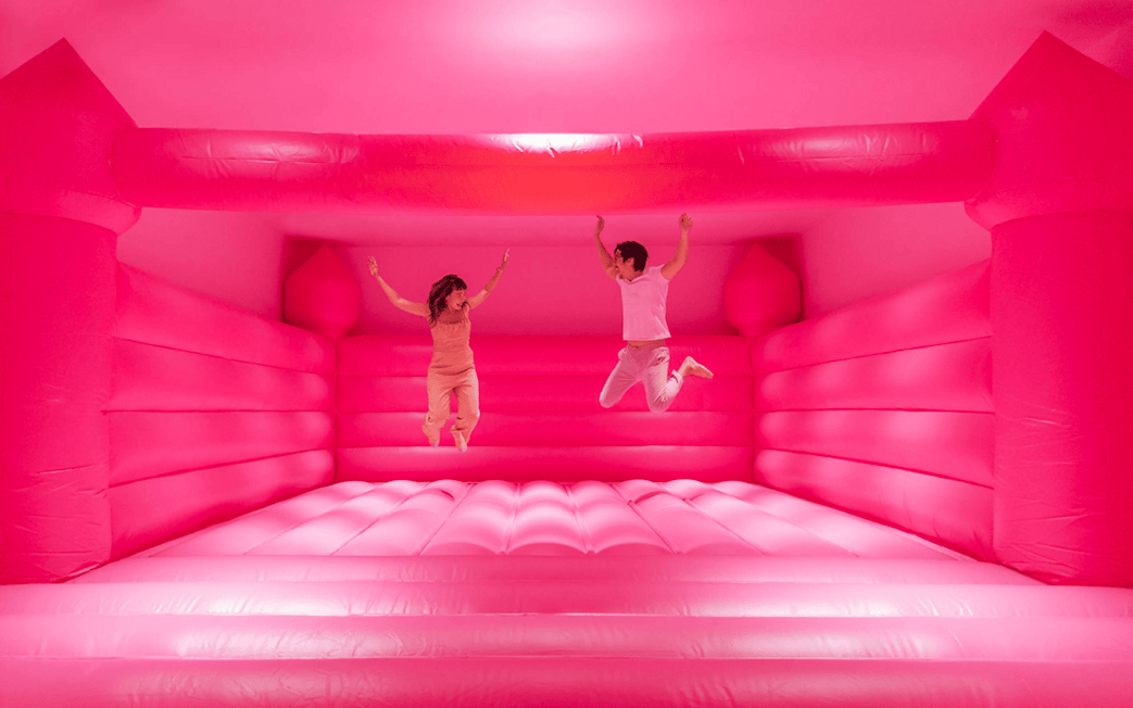 Visitors jumping in a pink bounce house at Museum of Ice Cream Singapore exhibit.