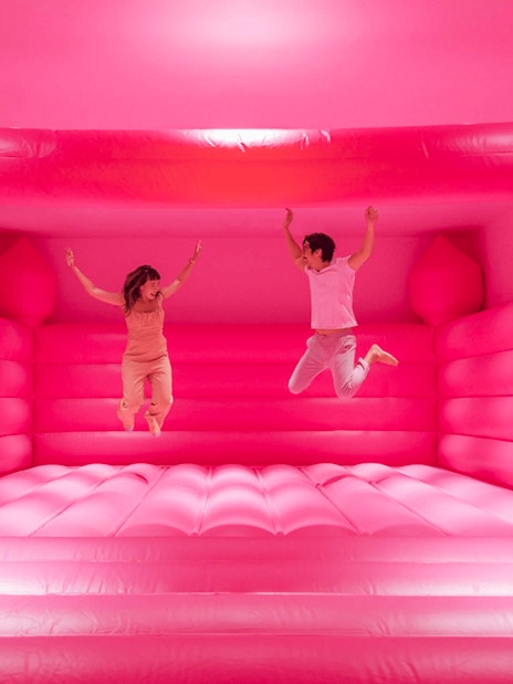 Visitors jumping in a pink bounce house at Museum of Ice Cream Singapore exhibit.