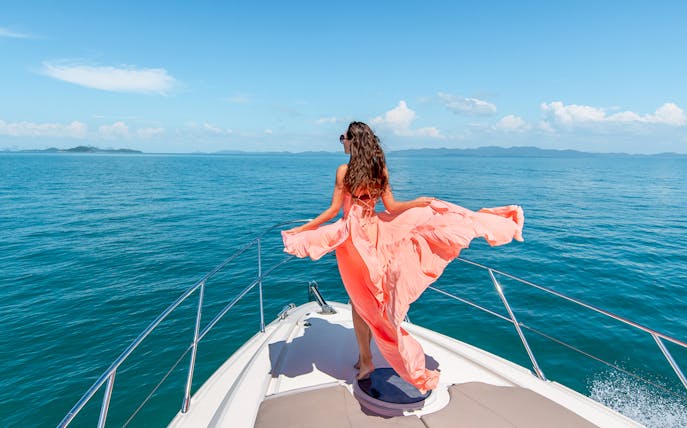 Woman on boat enjoying Baunei Coast during full-day guided tour.