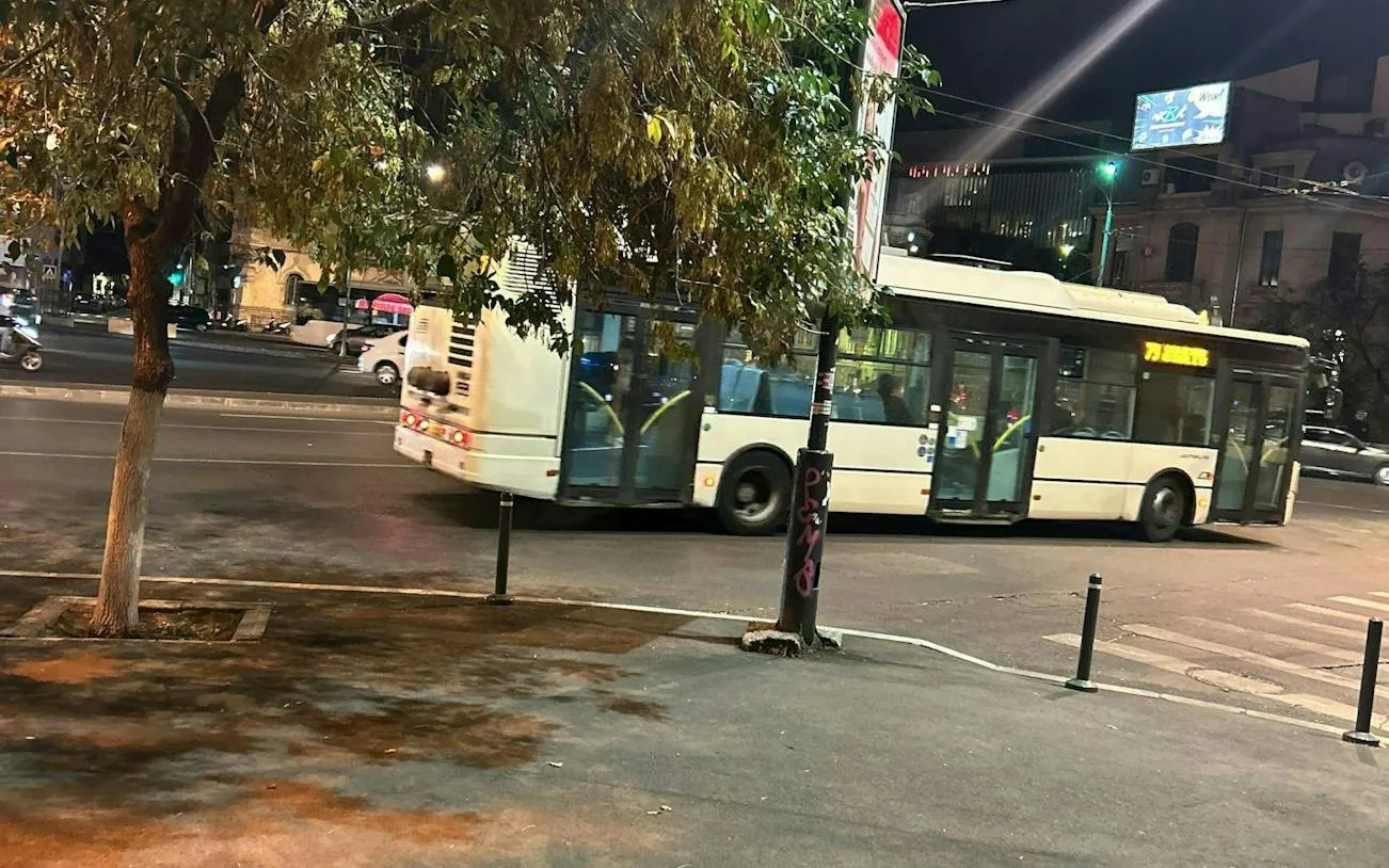 Nighttime city street in Bucharest with a bus passing by, part of the self-guided exploration game.
