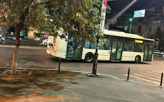 Nighttime city street in Bucharest with a bus passing by, part of the self-guided exploration game.
