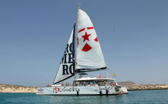 Catamaran sailing near La Graciosa Island with passengers enjoying the cruise.