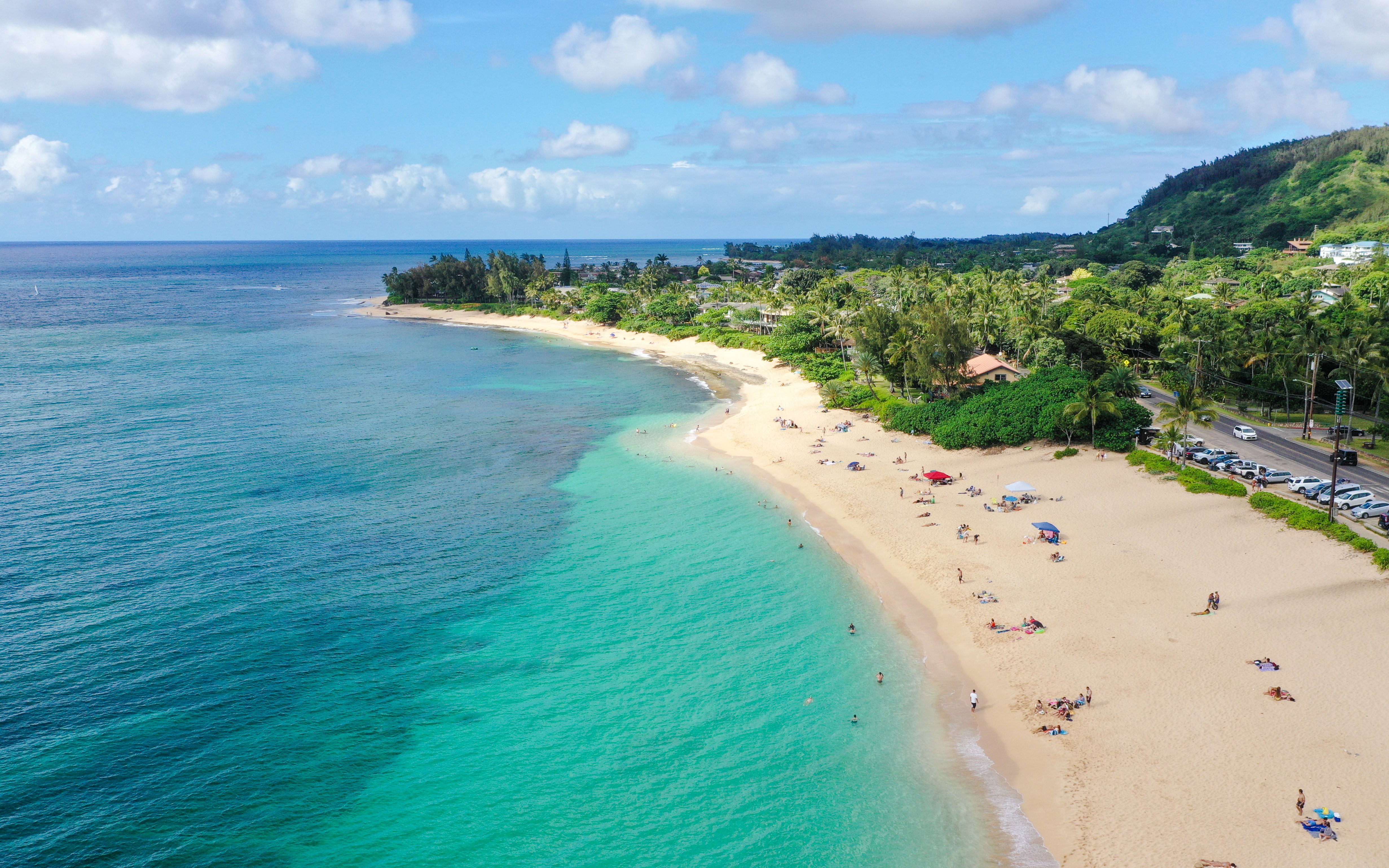 Aerial view of a sandy beach with turquoise waters near Kualoa Ranch, Oahu, Hawaii.