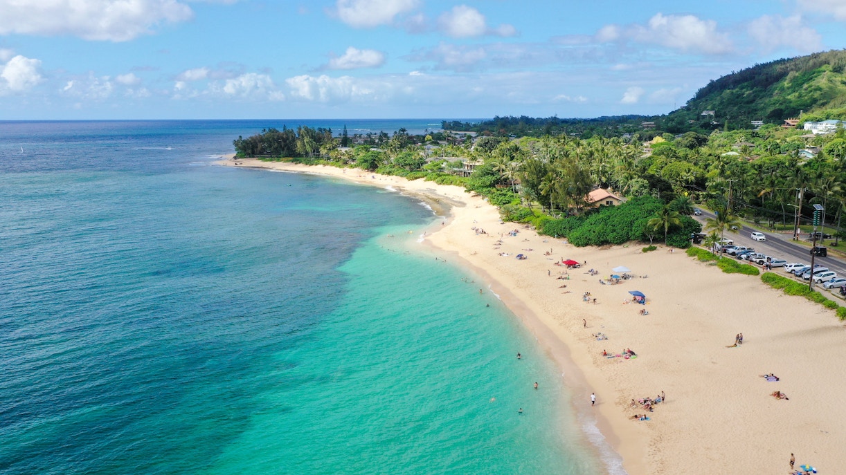 Aerial view of a sandy beach with turquoise waters near Kualoa Ranch, Oahu, Hawaii.