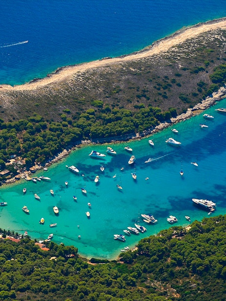 Aerial view of boats in a turquoise bay surrounded by lush greenery on a 5 Islands Hopping tour.