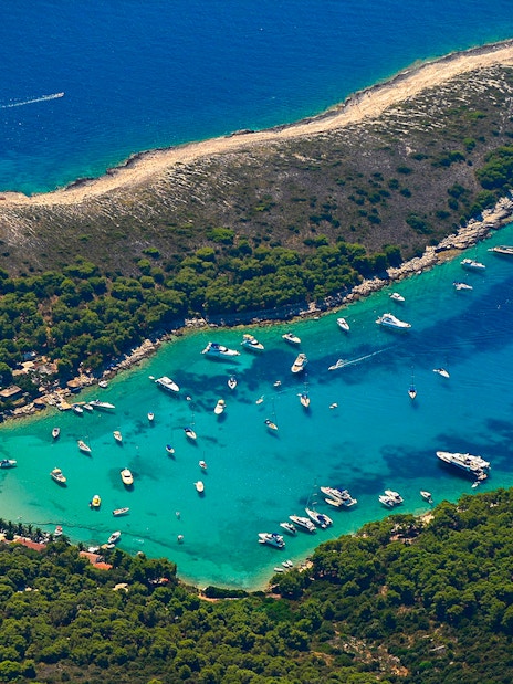 Aerial view of boats in a turquoise bay surrounded by lush greenery on a 5 Islands Hopping tour.