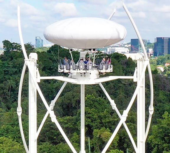 Skyhelix ride with passengers above lush greenery in Sentosa, Singapore.