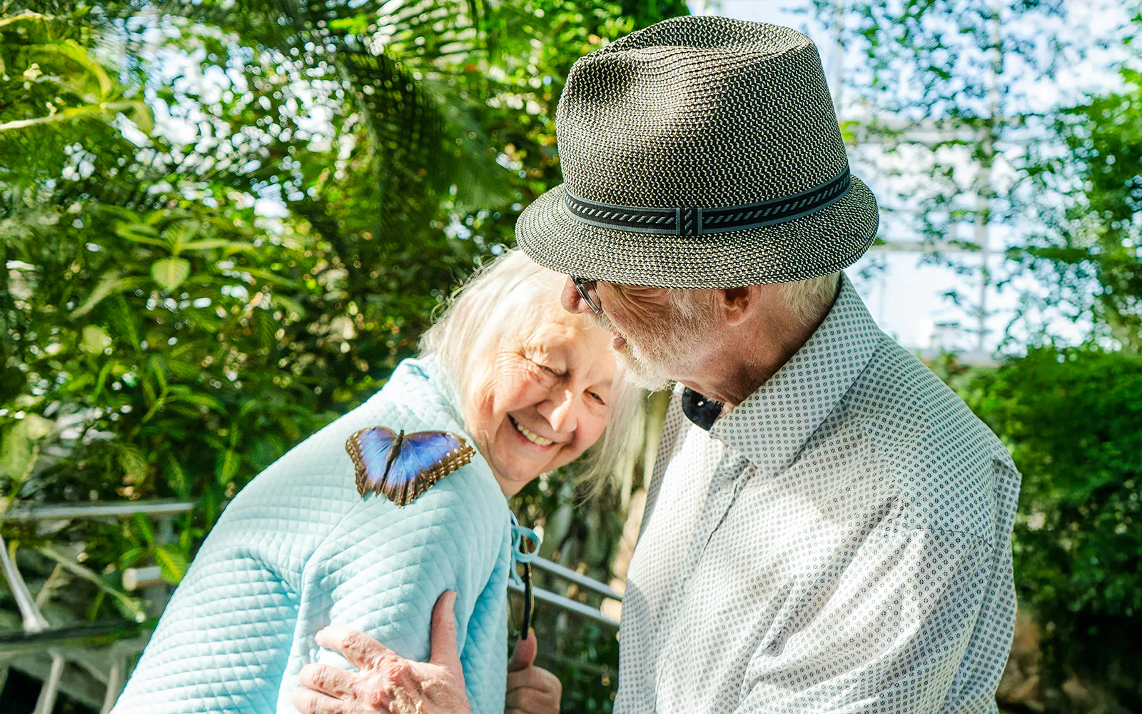 Elderly couple enjoying a butterfly on a shoulder at Niagara Falls Butterfly Conservatory, Canada.