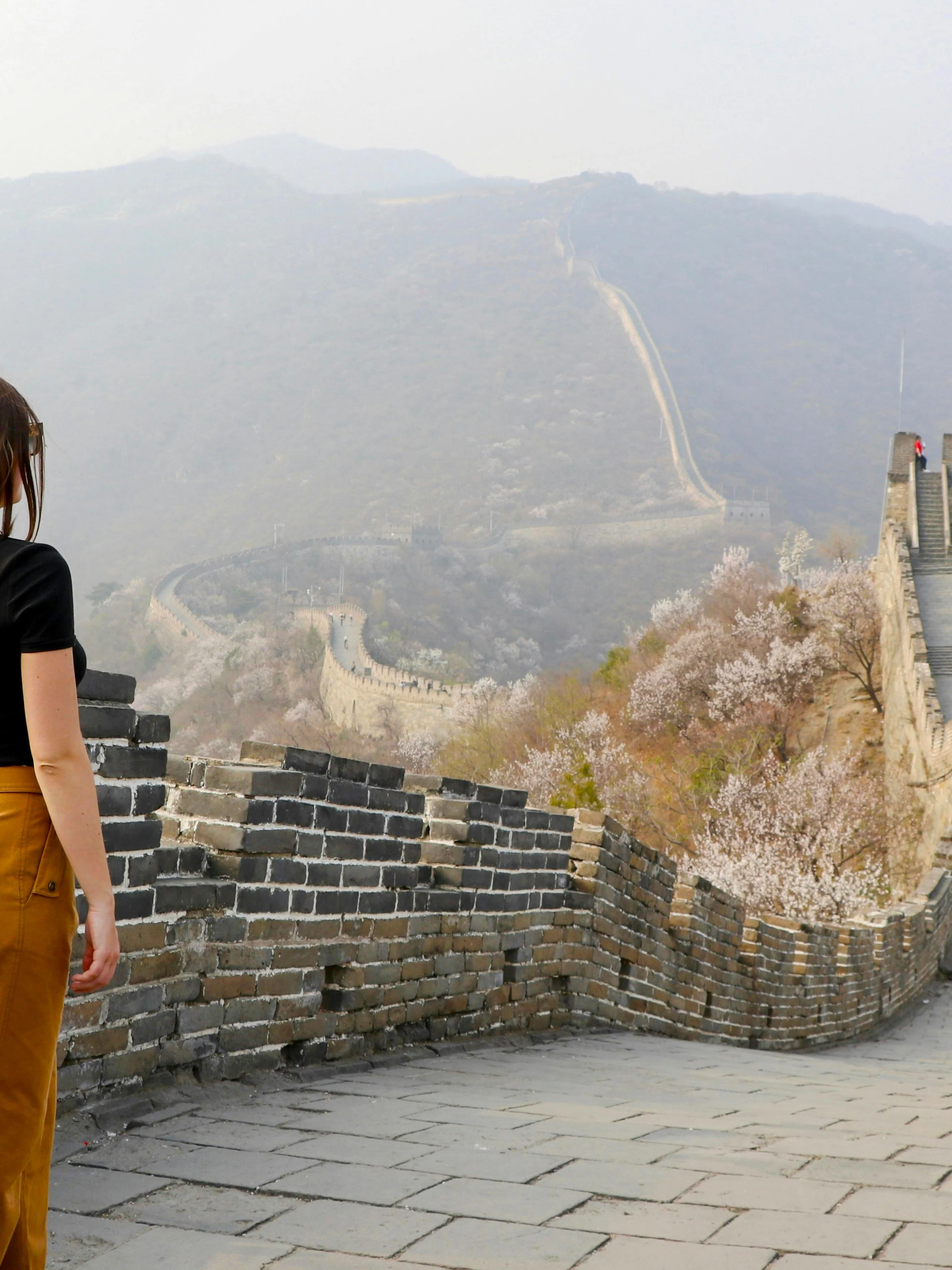 Young woman walking on Mutianyu section of the Great Wall of China, Beijing.