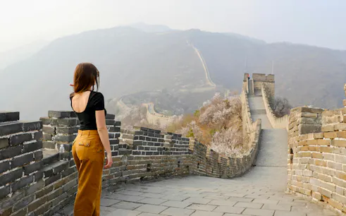 Young woman walking on Mutianyu section of the Great Wall of China, Beijing.