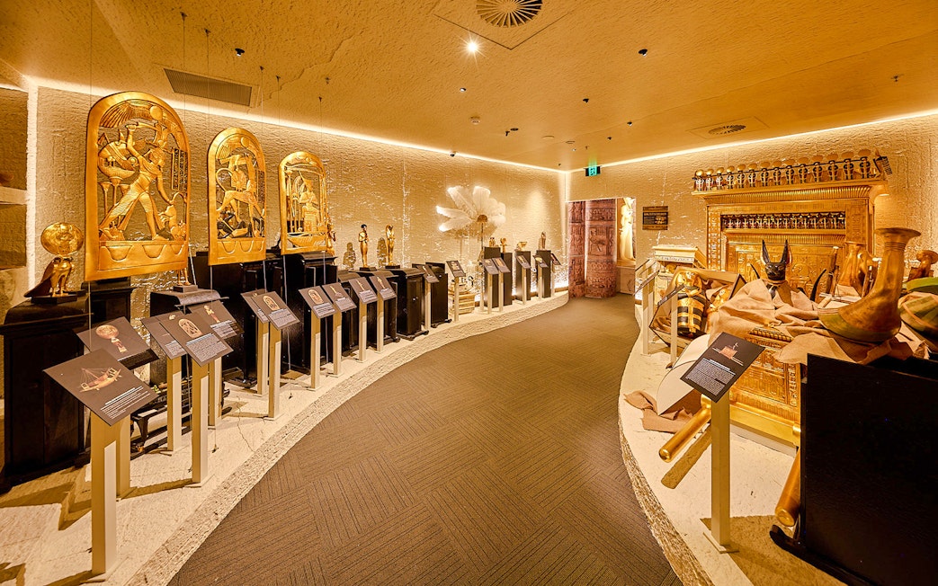 Golden Egyptian artifacts displayed in the Tomb of the Pharaoh exhibit room, Cairns.
