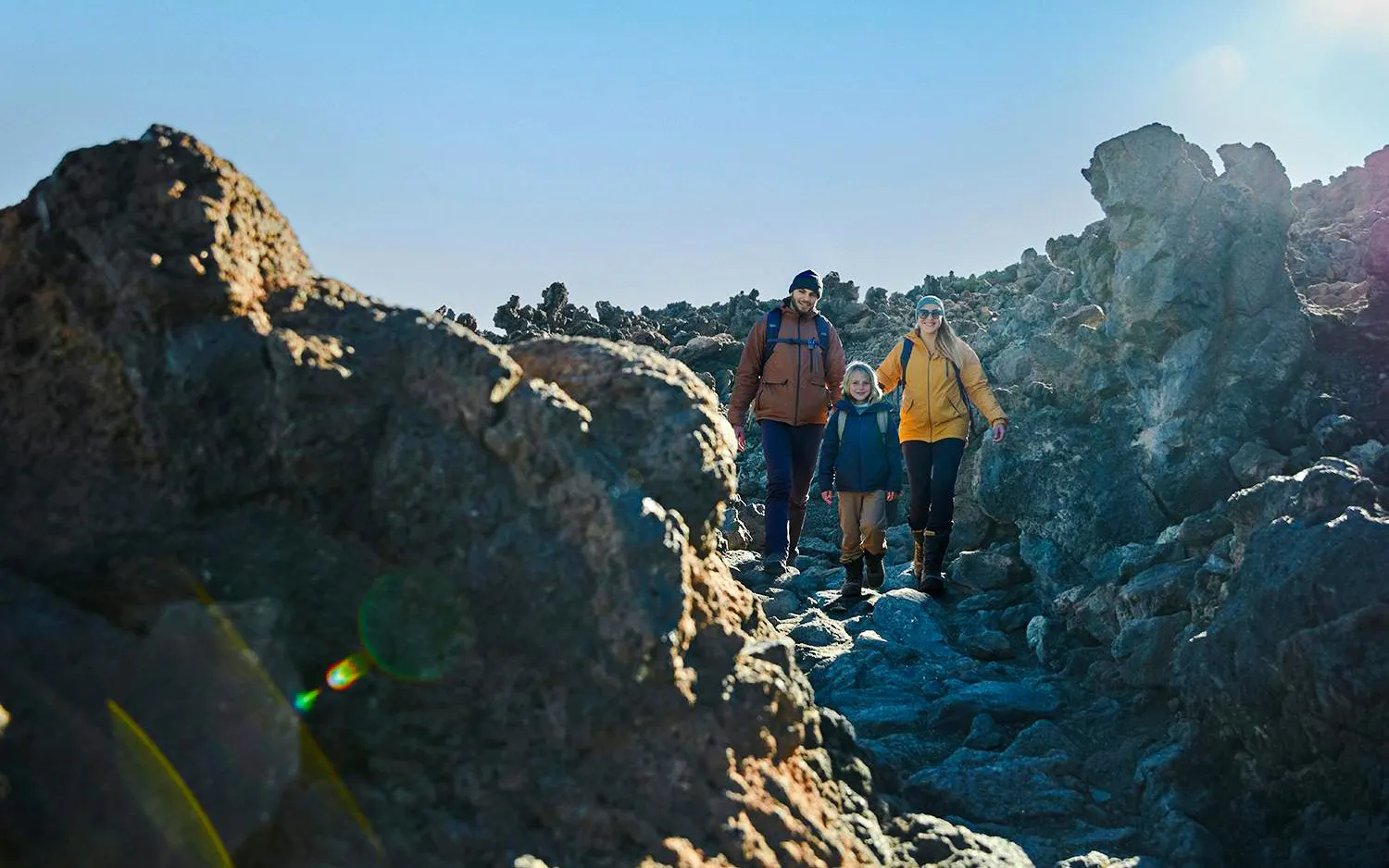 Family hiking on rocky trail at Mount Teide, Tenerife, with cable car tour.
