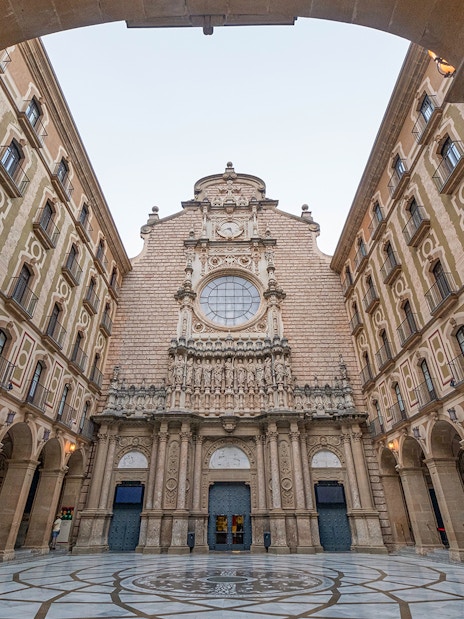 Montserrat Monastery entrance courtyard with ornate facade and archways.