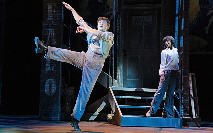 Performer dancing on stage with a partner near a stage door in a theater production of Gypsy.