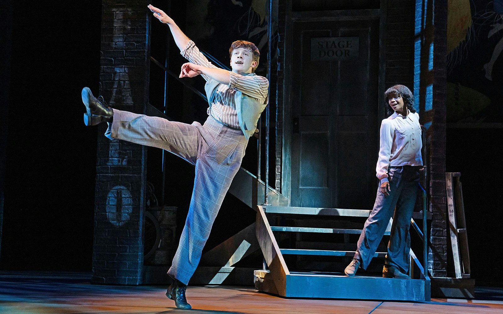 Performer dancing on stage with a partner near a stage door in a theater production of Gypsy.