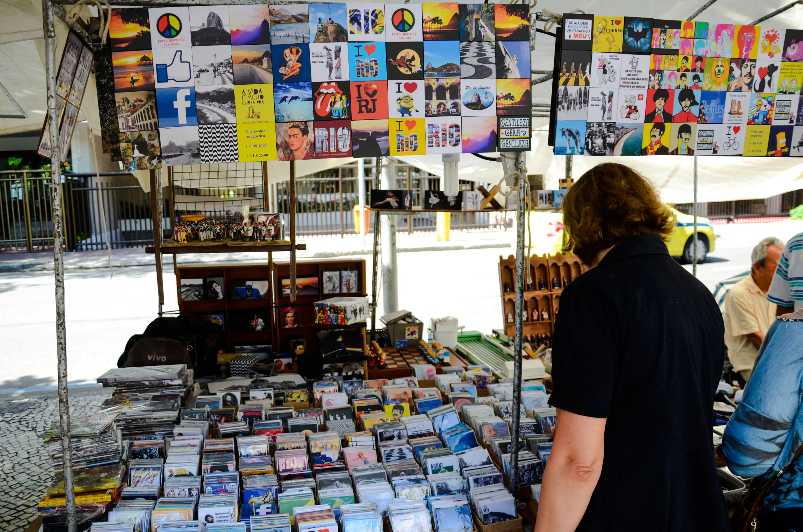 Local browsing Ipanema Street Market stalls with colorful souvenirs, Rio de Janeiro.