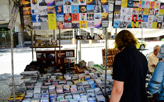 Local browsing Ipanema Street Market stalls with colorful souvenirs, Rio de Janeiro.