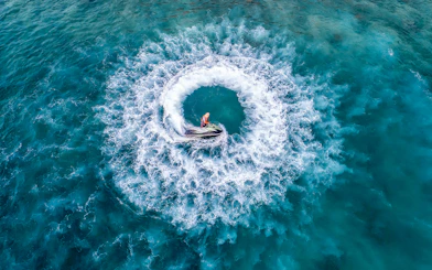Jet ski creating circular waves in Pattaya's turquoise waters during island day trip.