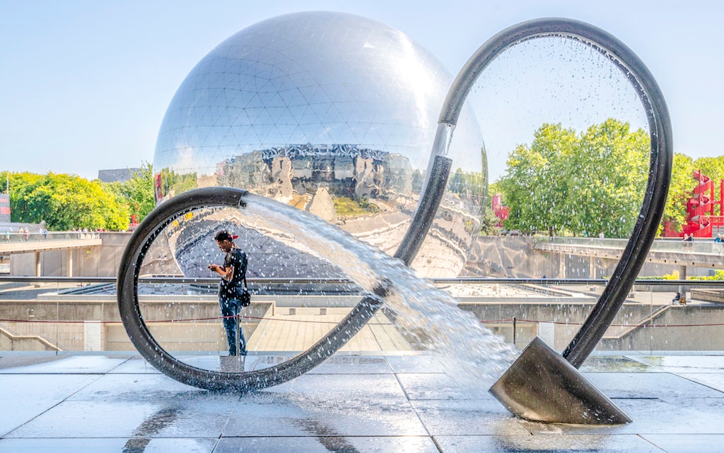 Exterior of Science & Industry Museum in Paris with reflective dome and water sculpture.