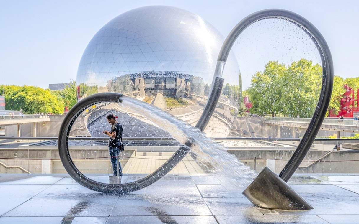 Exterior of Science & Industry Museum in Paris with reflective dome and water sculpture.