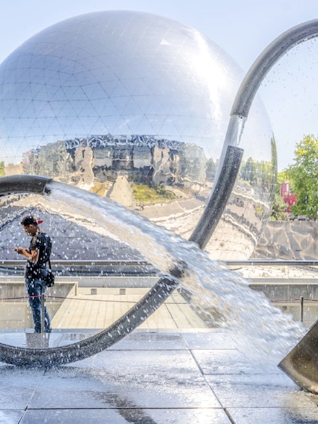 Exterior of Science & Industry Museum in Paris with reflective dome and water sculpture.
