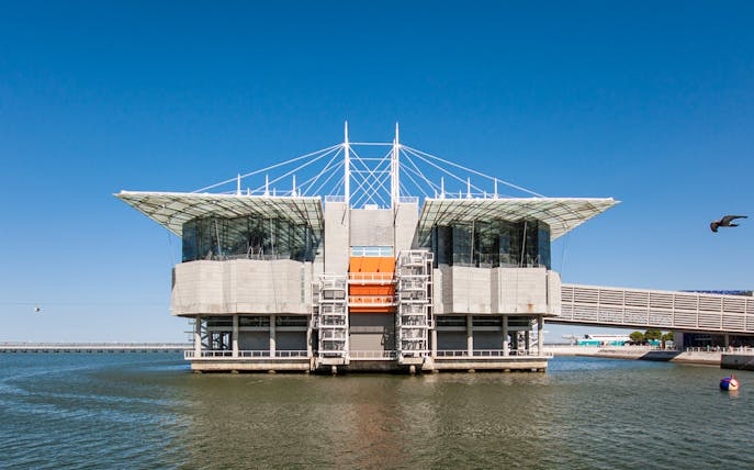 Lisbon Oceanarium building on water with clear blue sky, Portugal.