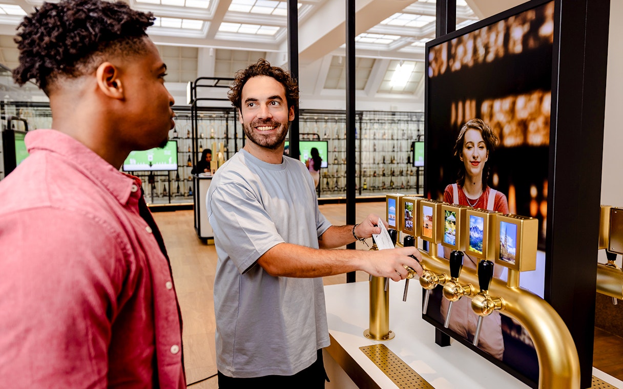 Guests interacting with beer taps at Belgian Beer World Experience in Brussels.