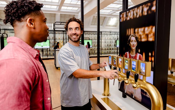 Guests interacting with beer taps at Belgian Beer World Experience in Brussels.