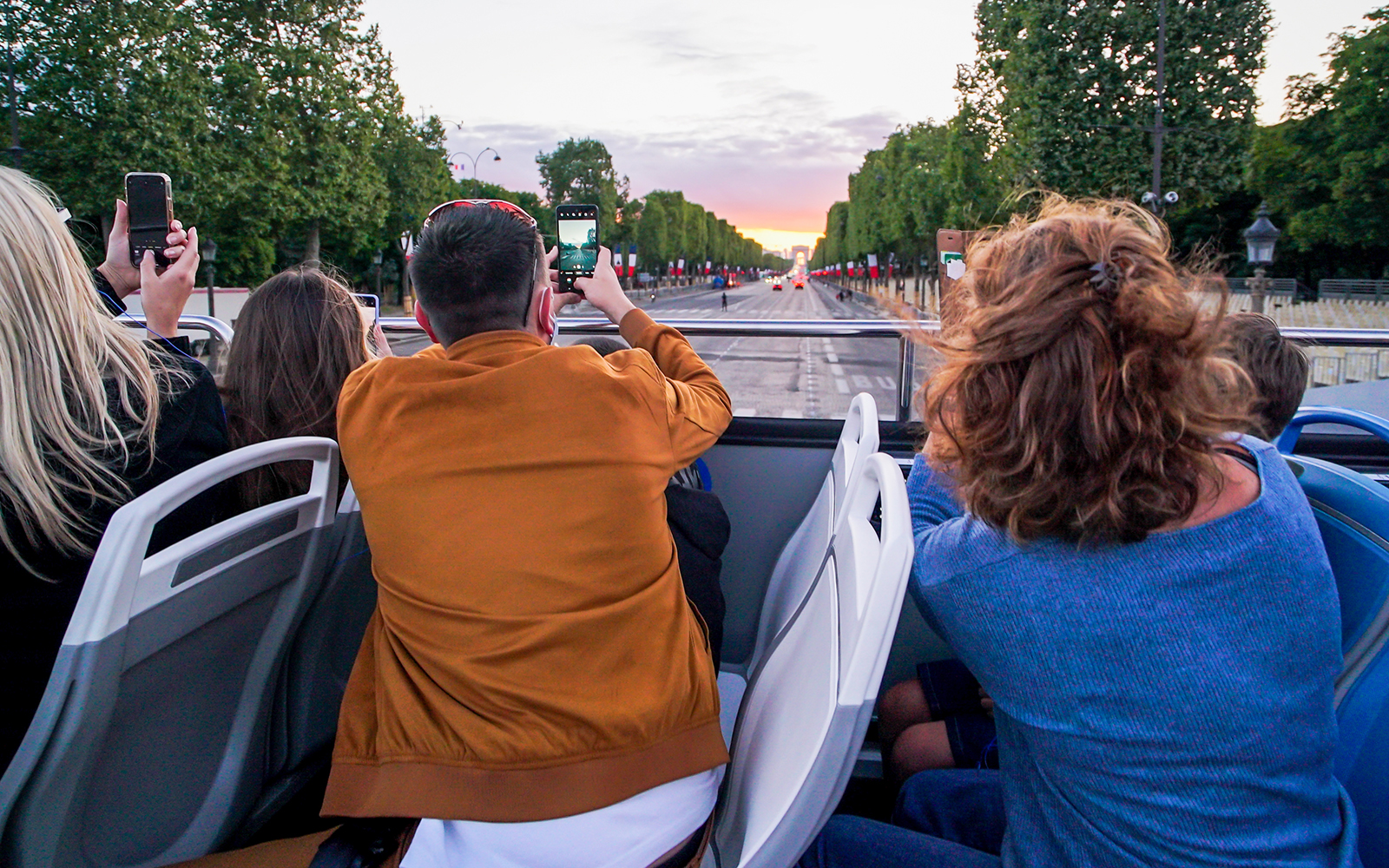 turistas fotografiando con sus teléfonos desde el bus turístico sevilla