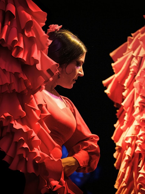 Flamenco dancers performing in vibrant red dresses in Barcelona.