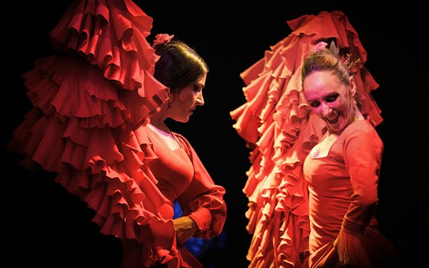 Flamenco dancers performing in vibrant red dresses in Barcelona.