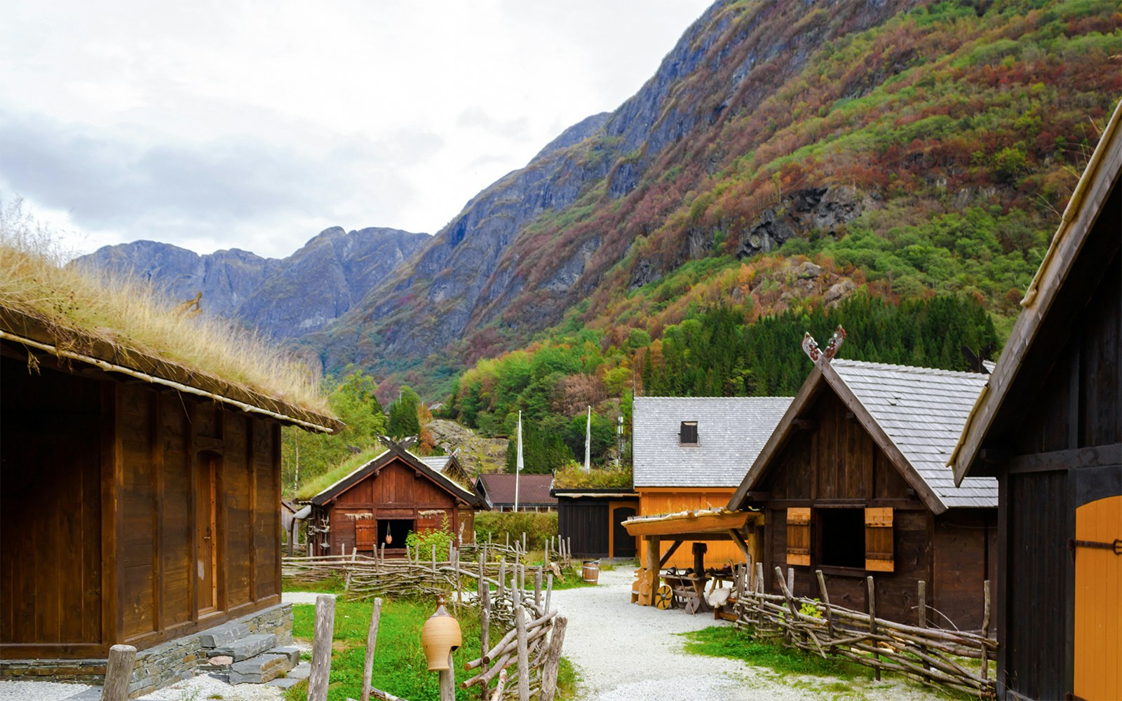 Viking village with wooden houses and mountains on a Guided Fjords tour.