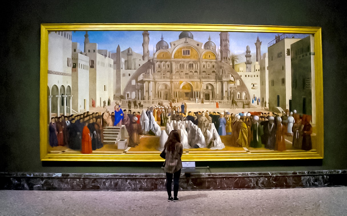 Visitor admiring a large painting at Brera Gallery, Milan.