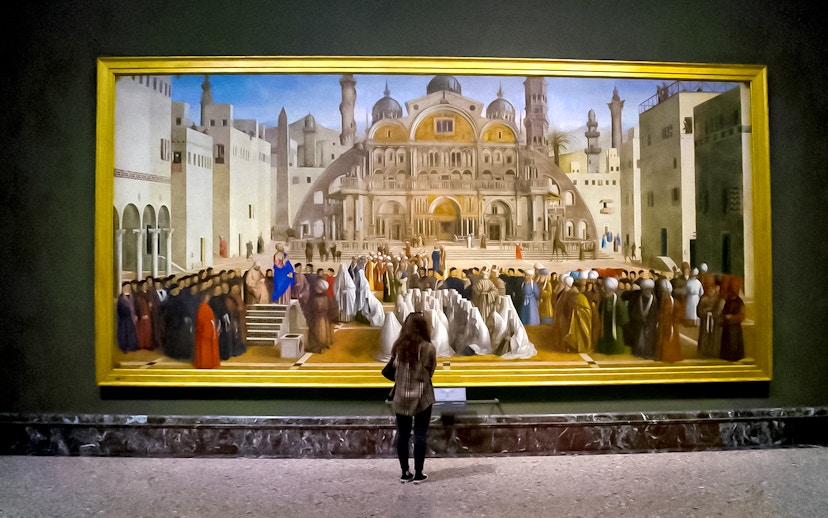 Visitor admiring a large painting at Brera Gallery, Milan.