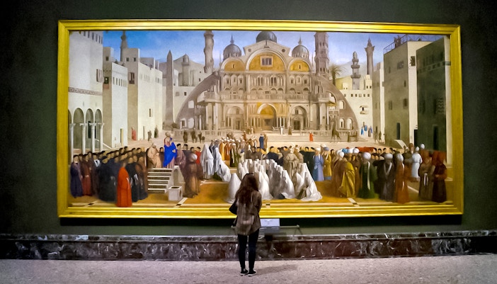 Visitor admiring a large painting at Brera Gallery, Milan.
