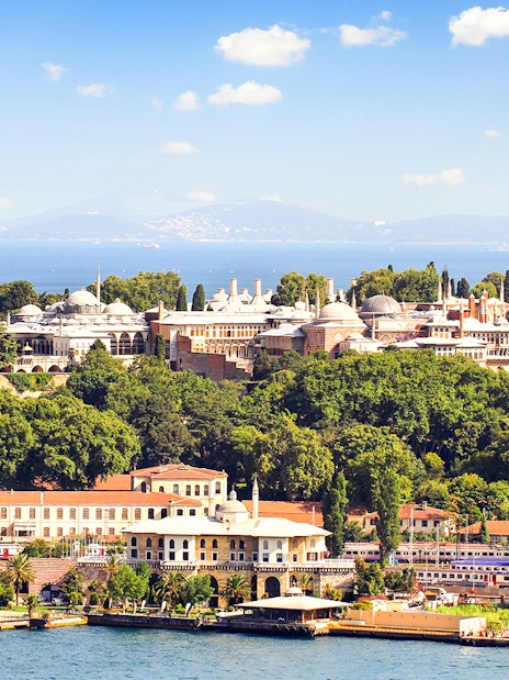Topkapi Palace surrounded by lush greenery with the Bosphorus in the background, Istanbul.